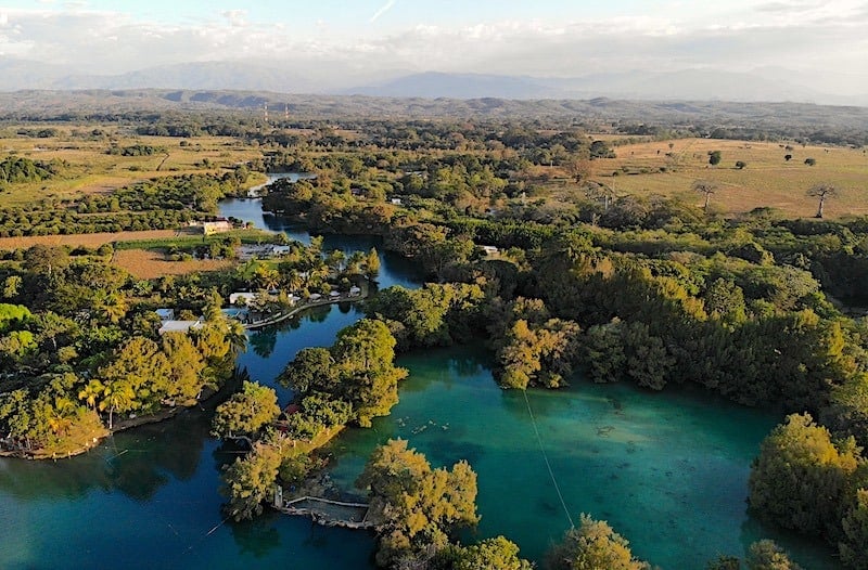 A drone shot of Lagos de Colon showing the blue color against the surrounding agricultural areas in Chiapas, Mexico.