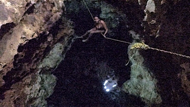Kristina from Off Path Travels hanging out on the rope in the narrow cenote Tzapakul