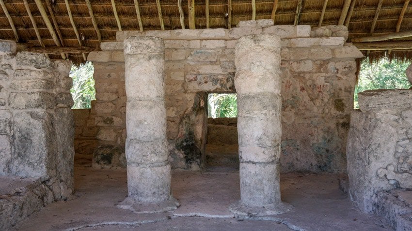The columns and red handprints at one of the best things to do in Cozumel, San Gervasio ruin site