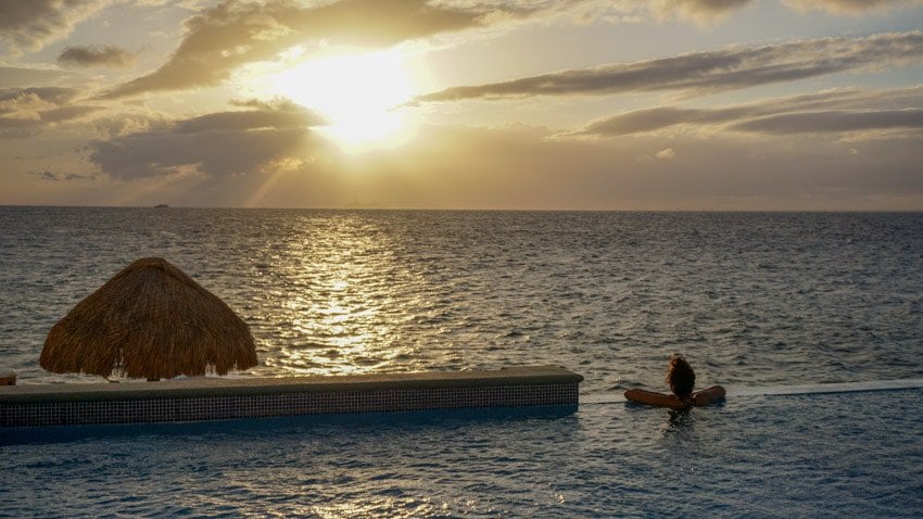 Kristina relaxing in our condo's pool during sunset, a great thing to do in Cozumel