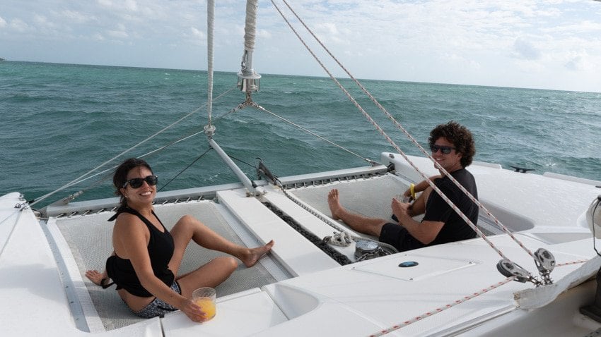 Kristina and Michael enjoying the front area on a catamaran on their wedding day in Placencia, Belize
