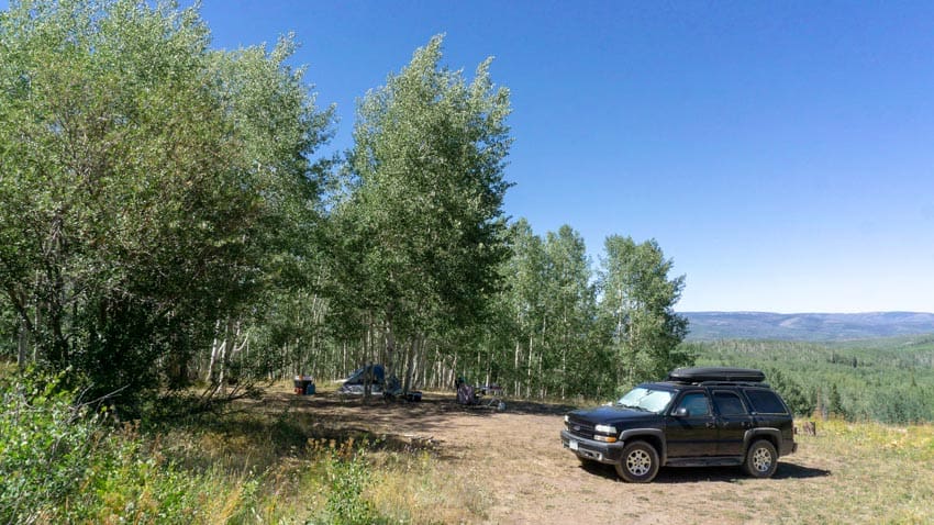 Our trusty Tahoe at a campsite tucked into a grove of aspen trees