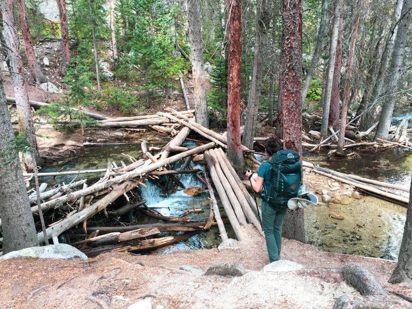 Kristina with backpack near stream