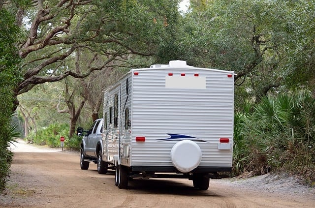 A truck with a hitch-mounted RV behind.