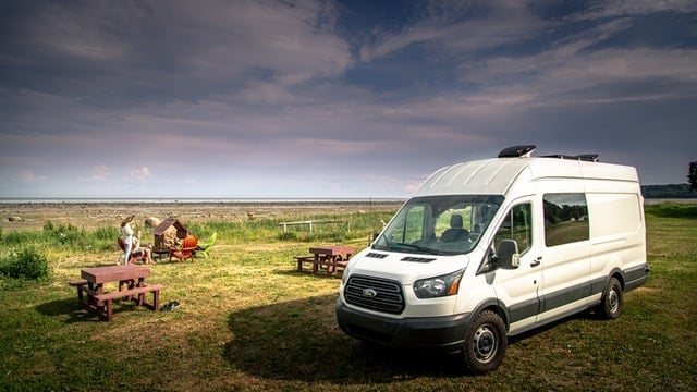 A Ford Transit sitting in a nice field.